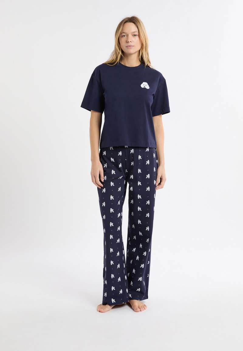 Granatowy bawełniany komplet piżamowy z krótki rękawem z logo oraz spodniami w deseń z nadrukiem małych białych postaci.