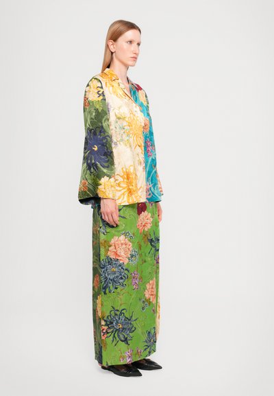 Floral-patterned, multicolored garment set. Features a green base with various flowers, long sleeves, and a maxi skirt. Fabric appears smooth.