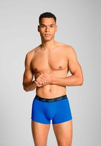 Blue boxer briefs with black waistband featuring the Puma logo. Made of smooth fabric, they have a fitted design and a comfortable cut.