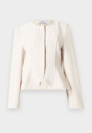 Κρεμ μπεζ γυναικείο σακάκι ραμμένο στο μέτρο με μακριά μανίκια, στρογγυλή λαιμόκοψη και κρυφό εμπρόσθιο κούμπωμα, απλωμένο επίπεδο σε λευκό φόντο.