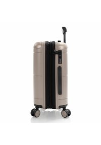 Valigia rigida in beige metallizzato con zip, serratura a combinazione e manico telescopico. Quattro ruote nere per una facile manovrabilità.