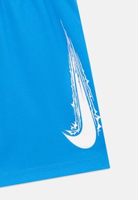 Shorts de sport bleus en tissu texturé, avec un logo Nike blanc bien visible et des accents graphiques dynamiques près du logo.