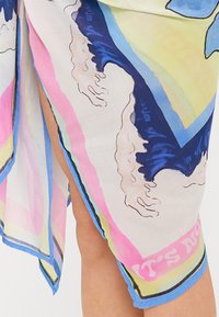 Sciarpa in chiffon leggera e multicolore con motivi astratti in blu, rosa e giallo, con un bordo a contrasto e dettagli testuali.