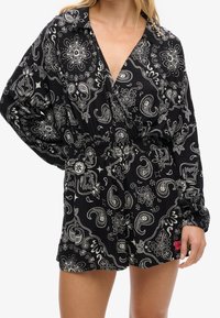 Mono negro con patrones de cachemir y flores en blanco. Mangas largas, diseño de escote en V y cinturilla elástica para un ajuste relajado.
