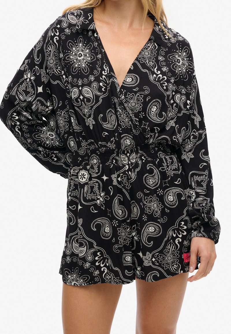 Mono negro con patrones de cachemir y flores en blanco. Mangas largas, diseño de escote en V y cinturilla elástica para un ajuste relajado.