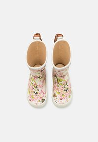Bottes imperméables blanches avec des motifs floraux roses et verts, dotées d'une semelle en caoutchouc texturée et de accents marron à l'arrière.