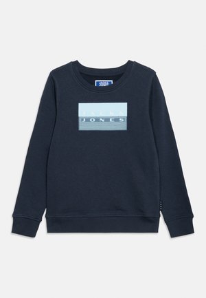 Tamnoplava majica dugih rukava s rebrastim rukavima i rubom, s pravokutnim svijetloplavim logotipom s tekstom "JACK & JONES" na prsima.