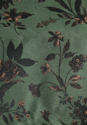 Žalias audinys su juodų ir rudų gėlių raštu, turintis tekstūruotą, briaunotą paviršių, kuris padidina gylį ir vizualinį interesą.