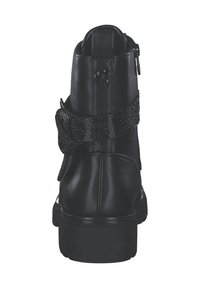 Bottine en cuir noir avec une sangle noire texturée et brillante, fermeture éclair à l'arrière et semelle épaisse. Présente un accent floral à l'arrière.