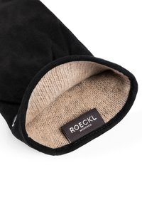 Black suede glove showing beige wool lining and Roeckl München brand label inside the wrist opening on white background.