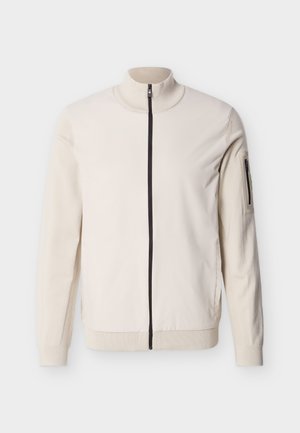 Bordo spalvos striukė su užtrauktuku per visą ilgį, subrėžta apykakle, rankogaliais, apačia ir kišene su užtrauktuku kairėje viršutinėje rankovėje.