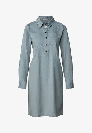 Jasnoniebieska, długa sukienka z długim rękawem i kołnierzykiem, zapinana na guziki z dwiema kieszeniami na piersi oraz lekko rozszerzanym dołem. Wykonana z miękkiego materiału.