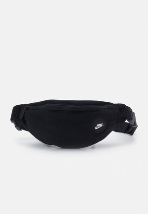 Sac banane noir Nike avec poche avant zippée et sangle réglable, arborant un petit logo rond Nike sur le devant.