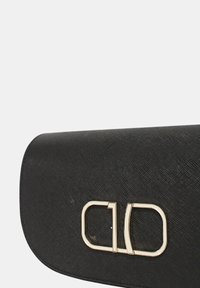 Borsa a pochette nera in tessuto con patta pieghevole, dotata di una chiusura in tonalità oro e design minimalista. Senza ulteriori decorazioni.