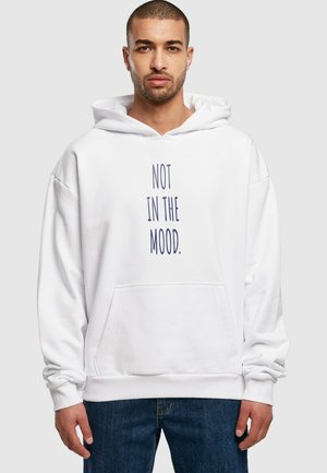 Hvid hoodie med en frontlomme og navy tekst der siger "IKKE I HUMØR." Casual design med lange ærmer og snøre i huen.