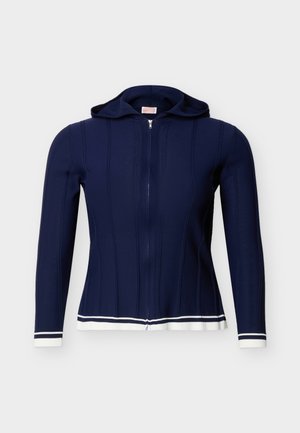 Μπλε ναυτικό φούτερ με φερμουάρ, κουκούλα και μακριά μανίκια, με λευκή ρίγα στο τελείωμα μανικιών και κάτω μέρος, σε φωτεινό φόντο.