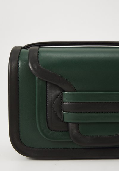 Sac à main en cuir vert foncé avec des accents noirs, présentant un design structuré, une surface texturée et un panneau avant superposé avec un rabat proéminent.
