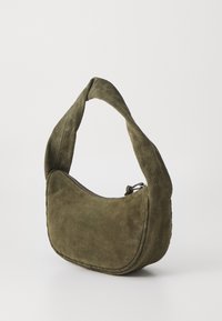 Borsa in suede verde oliva con una silhouette curva e una spallina spessa e annodata. Presenta una chiusura conzip e una delicata cucitura lungo il bordo.