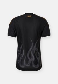 Chemise noire à manches courtes avec un motif de flammes grises dans le bas du dos et un texte jaune « YOUTH SINCE 1987 » près du col.