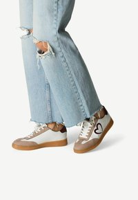 Sneaker mit einem beige-, weiß- und braunfarbenen Design; aus Wildleder und Leder; runde Zehenpartie; auffälliges Herzdesign; Gummisohle.