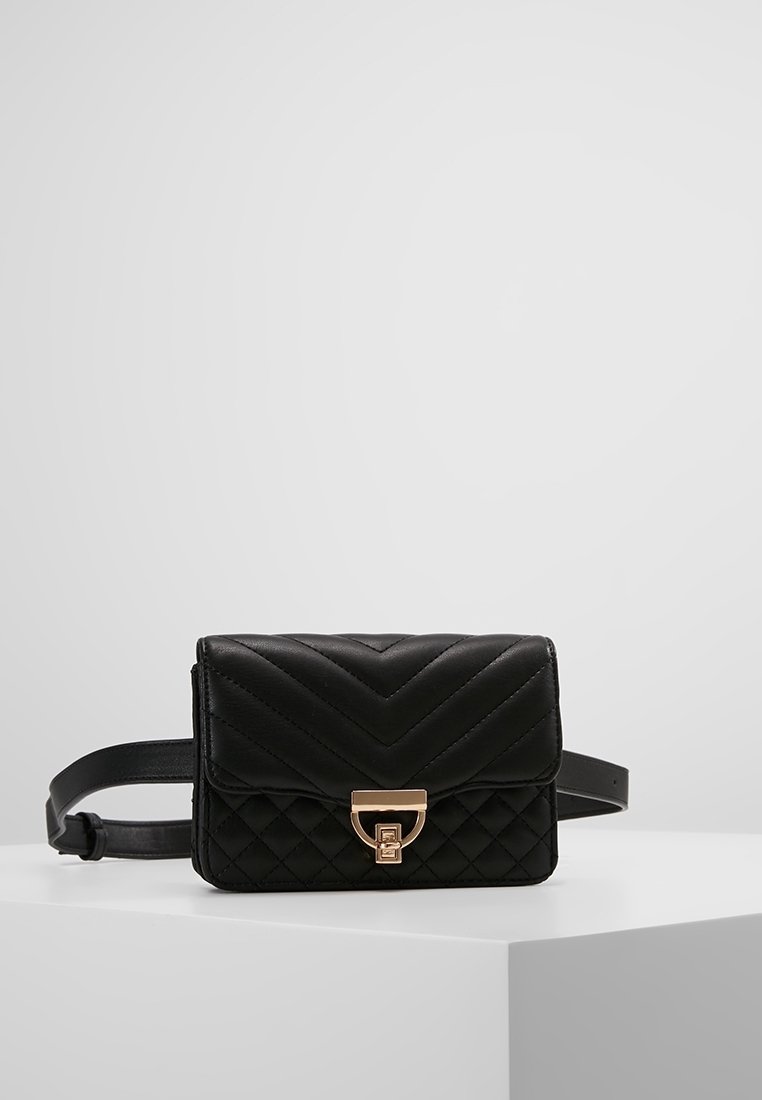 Borsa a tracolla nera trapuntata con motivo a zig zag, hardware dorato e una tracolla. Design compatto con chiusura a pattina e forma squadrata.