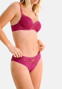 Magenta lingerieset met een bh met kantafwerking en bijpassende slip. De bh heeft onderbordes voor ondersteuning en verstelbare bandjes; de slip bevat doorschijnende accenten.