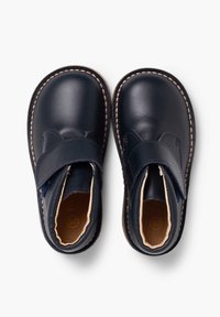 Zapatos de cuero azul marino con diseño de punta redondeada, correa ajustable, costuras color marrón y forro beige, exhibidos desde arriba.