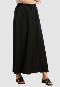 Lange zwarte rok van lichtgewicht stof, met een elastische tailleband en trekkoord, en subtiele gouden accenten.