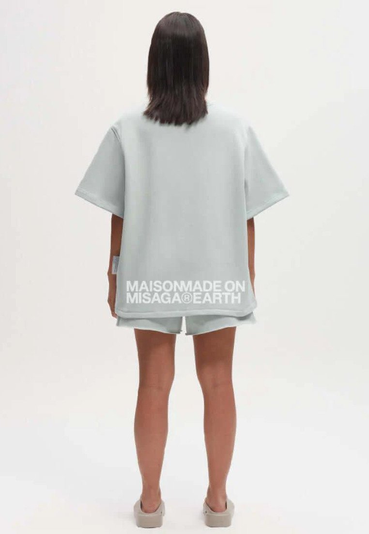 Lichtgrijs oversized t-shirt met korte mouwen en bijpassende shorts. Voorzien van het logo "MAISONMADE ON MISAGA®EARTH" op de rug. Soepele textuur.