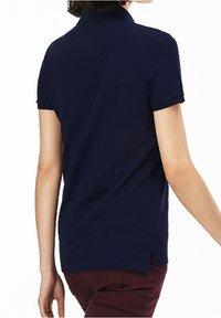 Polo shirt bleu marine en mélange de coton, avec des manches courtes, un col et des fentes sur les côtés à l'ourlet pour un confort supplémentaire.