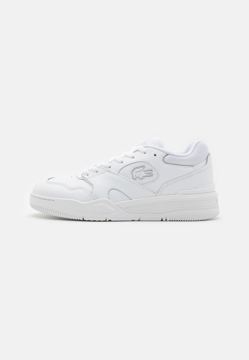 Fehér sportcipő, sima bőr felsőrésszel, hálós elemekkel, fűzős záródással és texturált gumi talppal. Lacoste logó az oldalon.