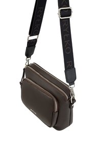 Brun læder crossbody taske med to lynlåslommer, tekstureret overflade og en mønstret sort stofrem med logo-detaljer.