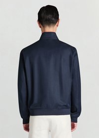 Veste en satin bleu marine avec col chemise, poignets et ourlet élastiques, de texture lisse et au design minimaliste.