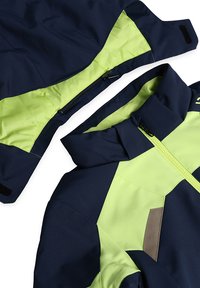 Navy- und limegrüner Jacke mit hohem Kragen, Reißverschluss und Klettverschluss-Akzenten. Verfügt über ein geometrisches Farbblockdesign und eine glatte Textur.