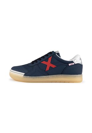 Zapatillas de lona azul marino con un logo 'X' bordado en rojo, cordones negros y suela de goma. Detalles plateados en el talón.