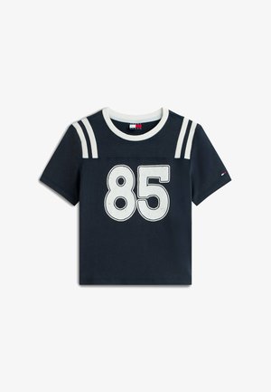 Donkerblauw shirt met korte mouwen, witte kraag, twee witte schouderstrepen en een groot wit cijfer "85" op de voorkant.