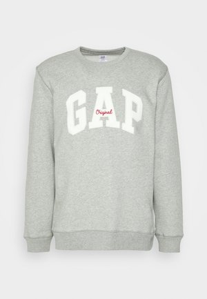 Sweat-shirt gris clair à col ras du cou avec "GAP" en grandes lettres blanches et "Original" en petite écriture rouge centrée sur la poitrine.