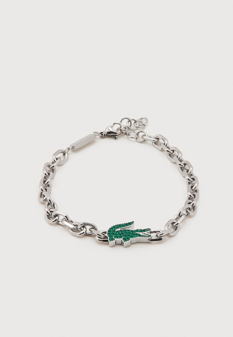 Ασημένιο βραχιόλι αλυσίδα με πράσινο χάντρα σε σχήμα κροκόδειλου και κούμπωμα με κλαμπόν, πάνω σε λευκό φόντο.