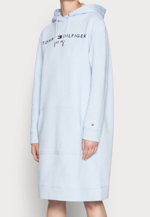 Lyseblå Tommy Hilfiger hættetrøjekjole med frontlomme, logotekst på brystet og lille logo på ærmet.