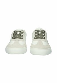 White sneaker with light gray suede accents, round toe, and olive green laces. Features a thick white sole and a logo on the tongue.
