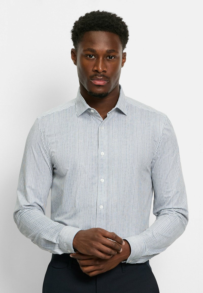 Weiß- und blau gestreiftes Langarmhemd mit spitzem Kragen, Knopfleiste und geknöpften Ärmeln, aus leichtem Stoff gefertigt.