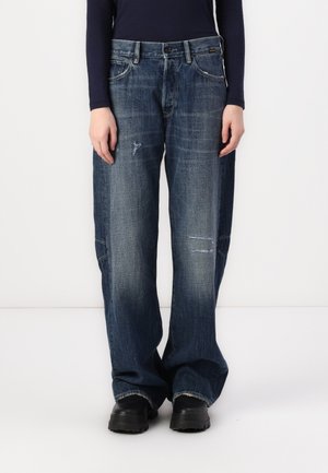 Wide-leg blue denim jeans with a faded finish, featuring distressed patches and a traditional five-pocket design.