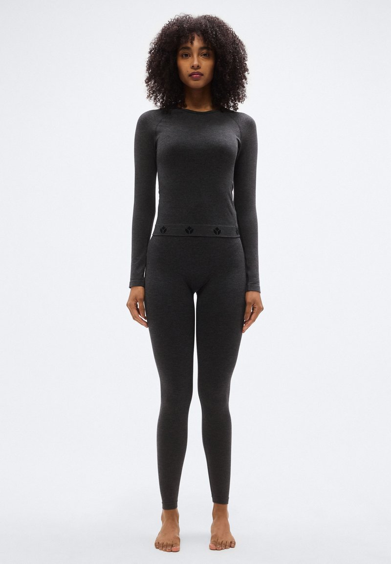 Μακρυμάνικη μπλούζα σκούρου γκρι χρώματος και αντίστοιχο κολάν από μαλακό, ελαστικό ύφασμα· διαθέτουν διακοσμητική μέση με λεπτό σχέδιο.