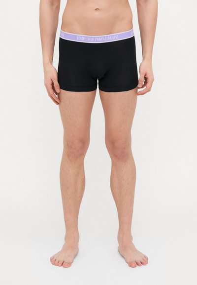 Shorts de boxe noirs avec une ceinture de marque en violet clair. Fabriqués en tissu lisse, présentant un ajustement serré et sans motifs ni accents visibles.