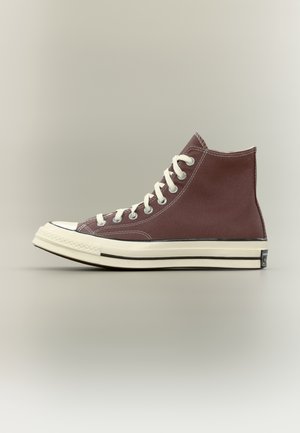 Højcanvas sneakers i mørkebrun med hvide snørebånd og tyk gummisål, vist fra siden på en neutral baggrund.