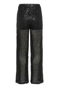 Pantaloni neri a gamba larga con una parte superiore di paillettes e una parte inferiore in tessuto trasparente e lavorato. Il tessuto presenta un aspetto testurizzato e pizzo.