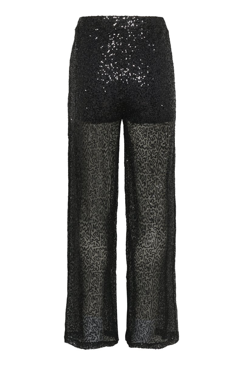 Sorte breddebenbukser med en glitrende overdel og en gennemsigtig, mønstret nederste del. Stoffet har et tekstureret, blonderlignende udseende.