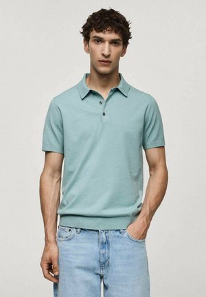 Lyseblå polo t-shirt med korte ærmer, spidse krave og tre-knaps placket; glat tekstur og tætsiddende talje. Bæres med lyse denim jeans.