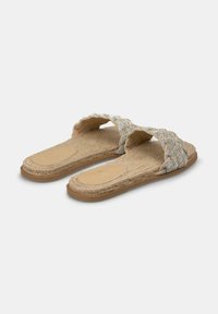 Infradito beige con un cinturino intrecciato decorato con paillettes argento, dotati di una suola in juta strutturata e un design piatto per il massimo comfort.