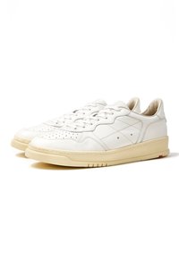 Sneaker bianche in pelle con una superficie liscia, dotate di dettagli perforati, profilo basso e suola in gomma color crema.